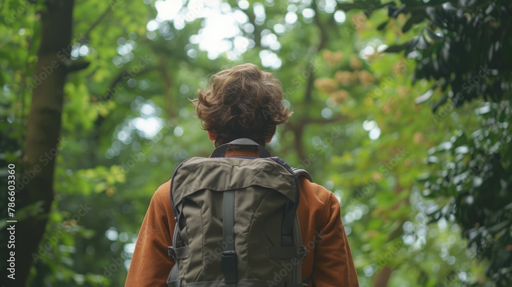 A man with a backpack walking through a forest. Suitable for outdoor and adventure themes A man with a backpack walking through a forest. Suitable for outdoor and adventure themes