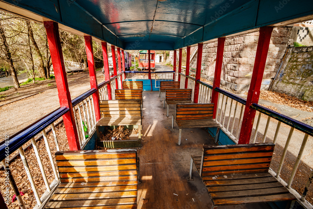 Vintage outdoor train carriage with with rows of wooden seats, old-fashioned railway carriage.