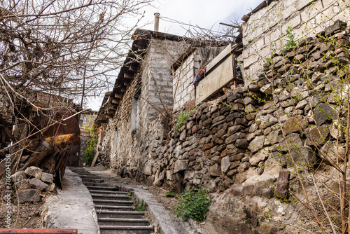 Weathered steps amidst rustic village walls. Classic rural landscape.