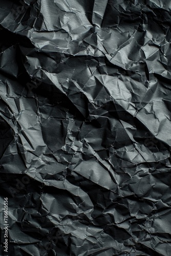 Detailed close up of a piece of black crumpled paper. Suitable for office or education themes