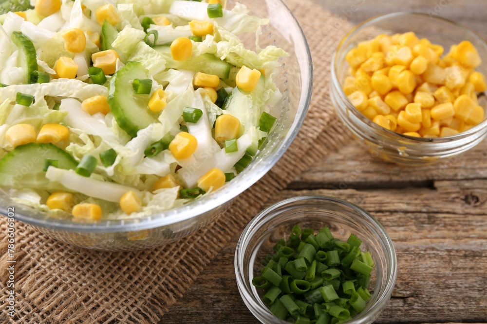 Tasty salad with Chinese cabbage, corn and green onion on wooden table, closeup Tasty salad with Chinese cabbage, corn and green onion on wooden table, closeup