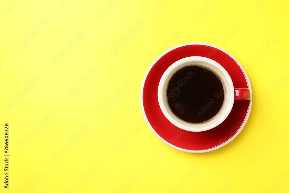 Aromatic coffee in cup on yellow background, top view. Space for text Aromatic coffee in cup on yellow background, top view. Space for text