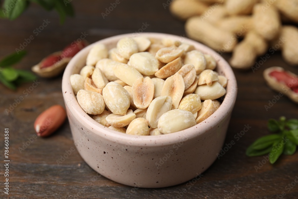 Fresh peeled peanuts in bowl on wooden table, closeup Fresh peeled peanuts in bowl on wooden table, closeup