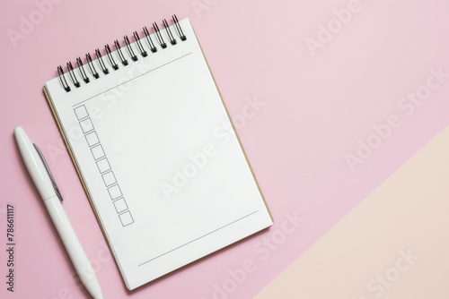 Minimalist to-do list notepad with empty checkboxes beside a white pen on a soft pink surface