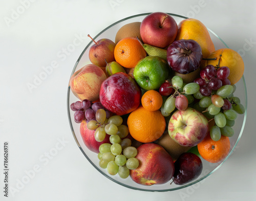 A bowl of fruit with apples  oranges  and grapes. The bowl is full and colorful  and it looks like a healthy snack