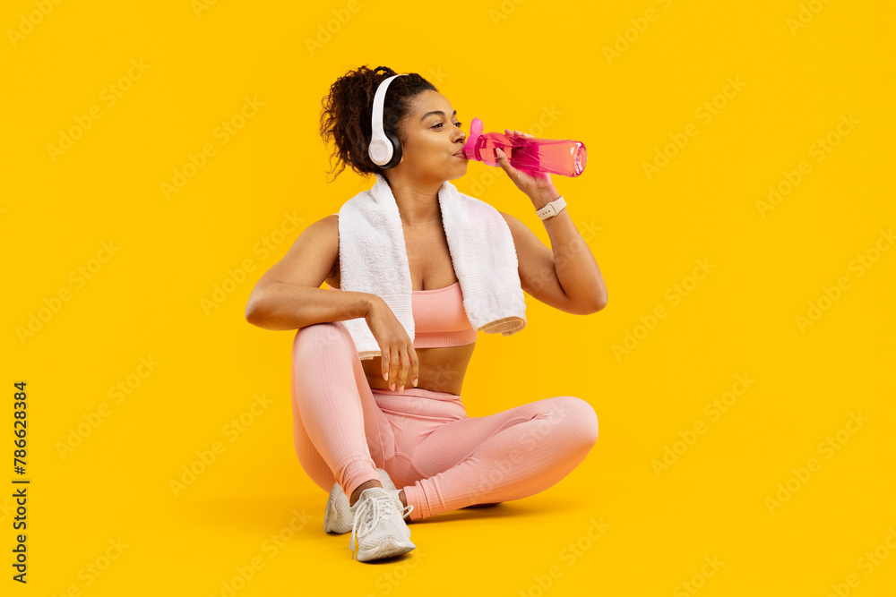 Woman sitting with water bottle after exercise Woman sitting with water bottle after exercise