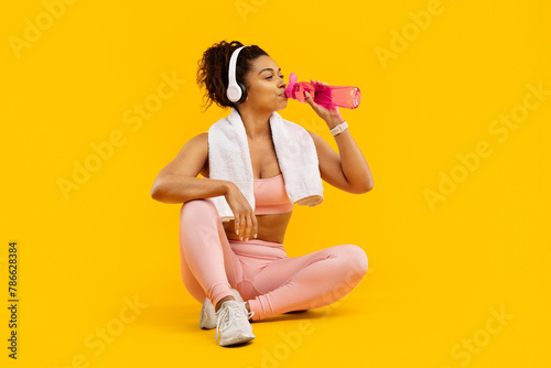 Woman sitting with water bottle after exercise photo