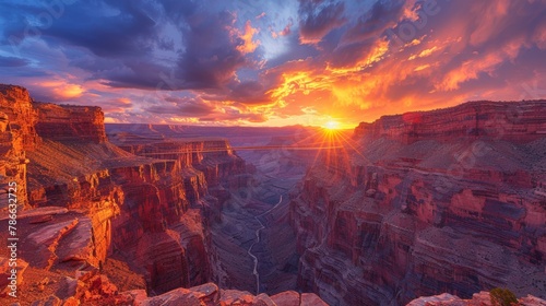Breathtaking sunset over a majestic canyon with a visible suspension bridge in a rugged landscape photo