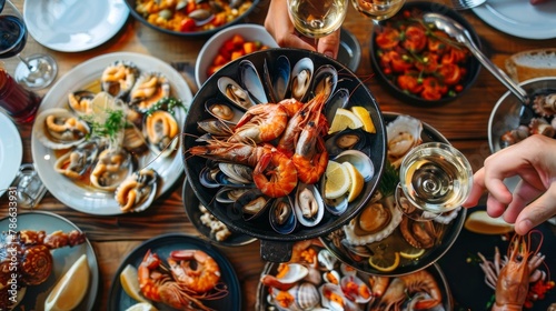 Assortment of seafood dishes on table with white wine glasses for elegant dining experience