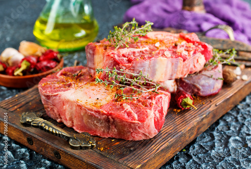 Top view of raw meat pieces placed on wooden tray sprinkled with salt