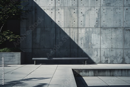 Stark shadows cast on a minimalist concrete wall and pavement, with a solitary bench invoking contemplation and modern design.