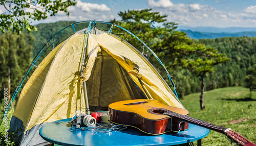 A yellow tent on a blue table with a guitar and trees © Nicolas