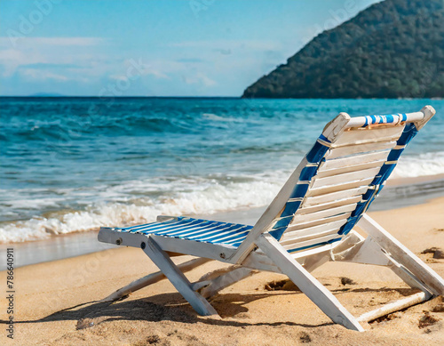 Beach deck chair on a sandy beach by the sea. Summer mood. Space to copy