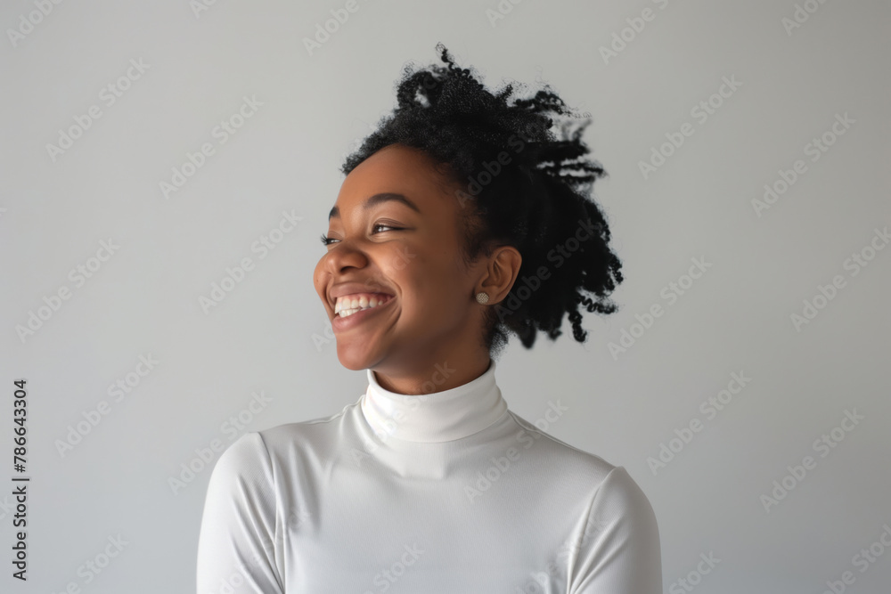 Obraz premium Dark-skinned girl with a beautiful smile in a white turtleneck on a white background