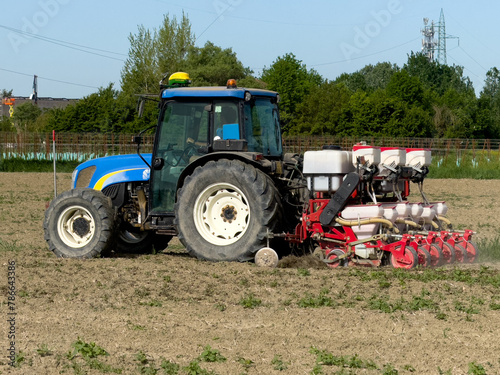 Trattore sowing, sowing crops in the field. Seeding is the process of planting seeds in the soil as part of agricultural activities in early spring.