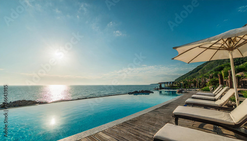 Sea view. Luxury modern white beach hotel with swimming pool at sunset. Sunbed on sundeck for vacation home or hotel resort