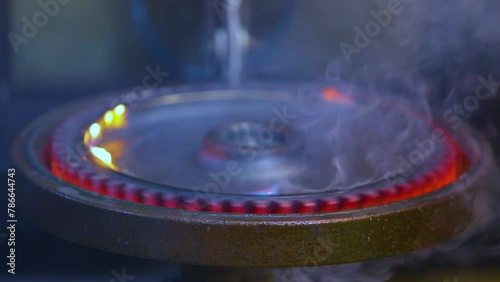 induction hardening process in a circular machine at a forging factory foundry. copper coil carrying current heating the metal gear. component in quenching in liquid to harden the surface.