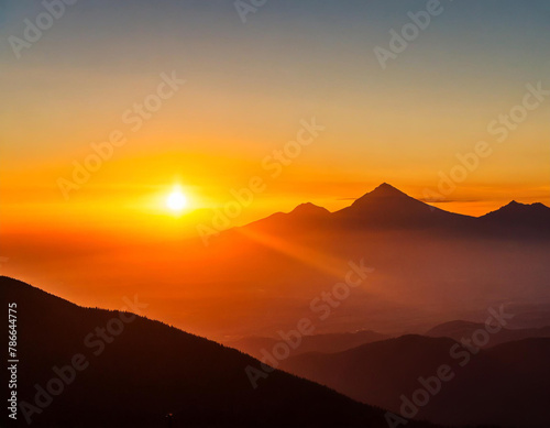 the sun is setting over a mountain range with mountains in the foreground and a red sky in the background