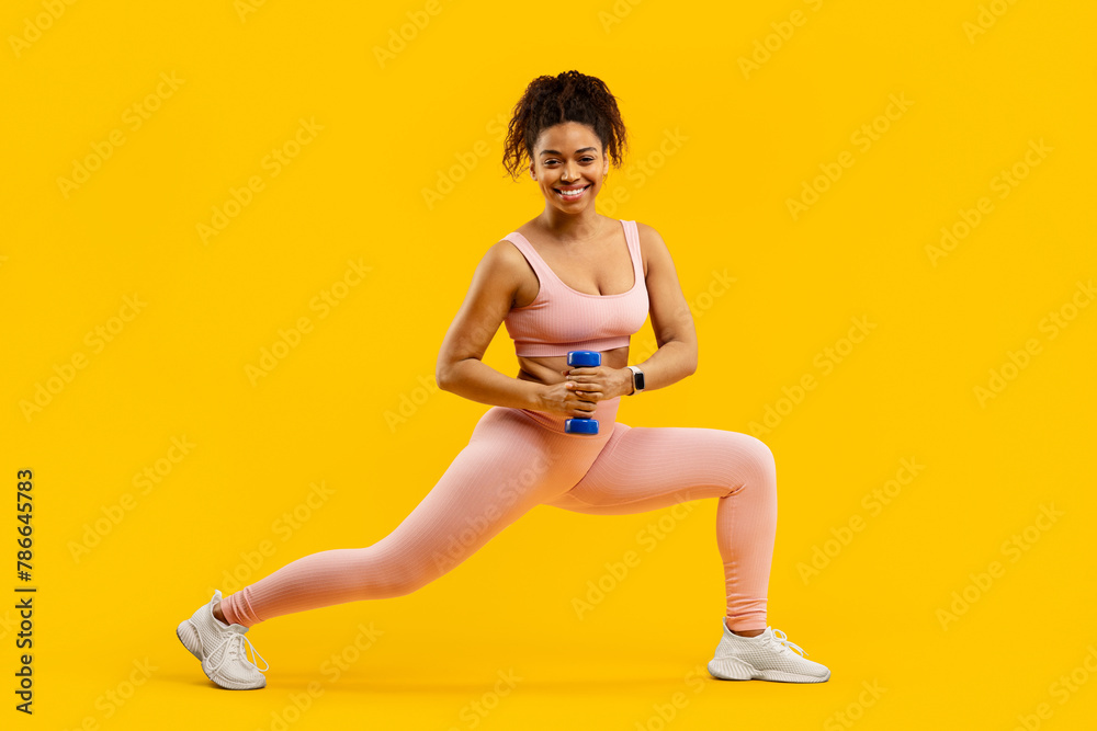 Lady doing lunges with weights on yellow Lady doing lunges with weights on yellow