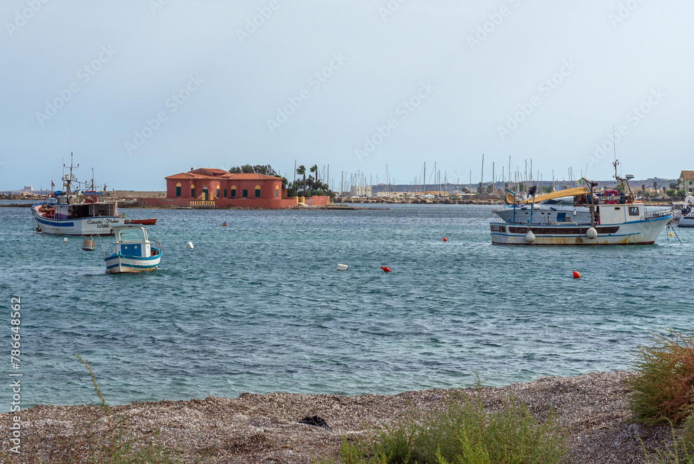Boats in harbour of Marzamemi village on the island of Sicily, Italy. View with Brancati Islet