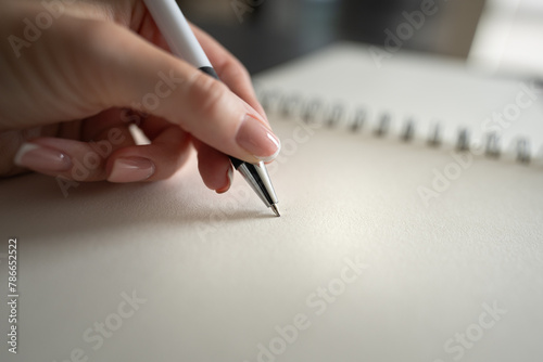 Hand of woman holding pen writing on notebook. Education and working concept.