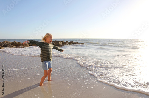 Happy Little Girl Child Playing in the Sun by the Ocean on Beach