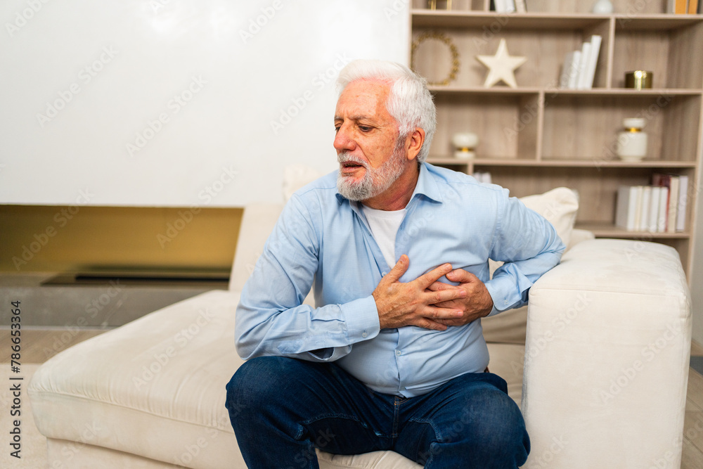 Pain on heart, heart attack. Unhappy middle aged senior man suffering from chest pain heart attack problems with health at home. Mature old senior grandfather touching chest experiencing infarction Pain on heart, heart attack. Unhappy middle aged senior man suffering from chest pain heart attack problems with health at home. Mature old senior grandfather touching chest experiencing infarction