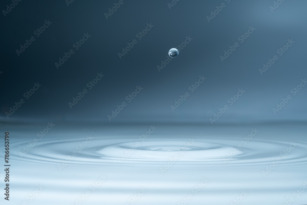 Close-up of a water drop and splash background, small impact causes big changes. Ripple, macro wave on surface of liquid Close-up of a water drop and splash background, small impact causes big changes. Ripple, macro wave on surface of liquid