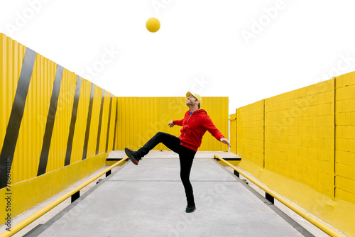 Playful adult kicking a ball in a colorful, striped arena photo