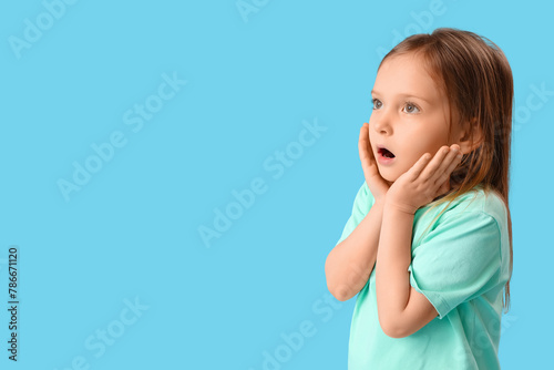 Shocked little girl on blue...