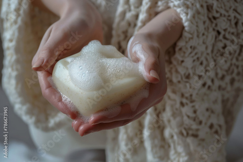 Close-up of a woman's hands lathering with rich, foamy goat milk soap photo