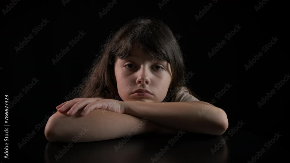 Child after family conflict on black. An upset little girl after conflict sitting in loneliness on the black background. Child after family conflict on black. An upset little girl after conflict sitting in loneliness on the black background.
