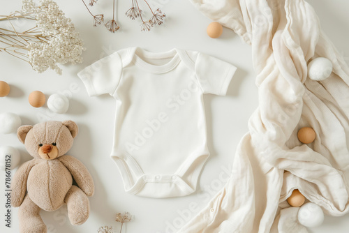 White cotton baby short sleeve bodysuit, teddy bear and natural wooden eco-friendly toys on pastel background. Infant onesie mockup. Blank gender neutral newborn bodysuit template mock up. Top view