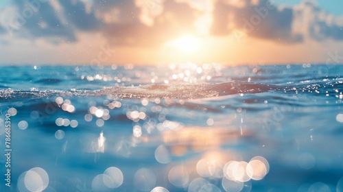 Calm sea with sun reflections creating a sparkling bokeh effect on the water surface, under a clear sky.