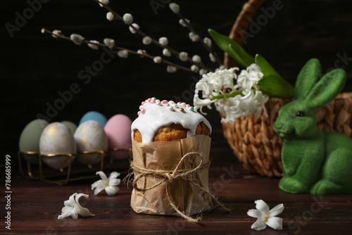 Easter cake, eggs, bunny, basket, hyacinth and willow branches on wooden background