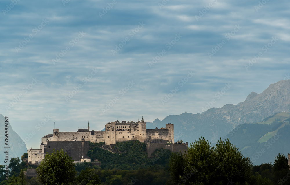 Salzburg, Austria, August 15, 2022. The fort dominates the city from the top of the hill, mountains in the background. Salzburg, Austria, August 15, 2022. The fort dominates the city from the top of the hill, mountains in the background.