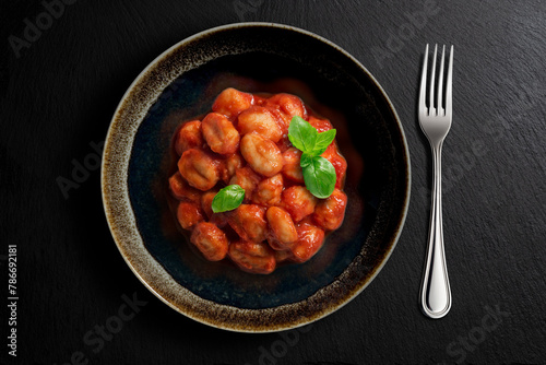 Dark bowl with tomato potato dumpling