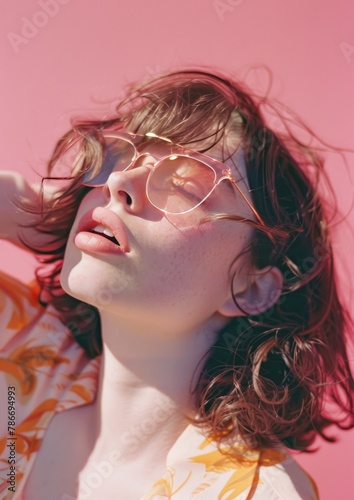 Portrait of girl kisses. Outdoors on a bright sunny day. Glasses and pink background. neon colour