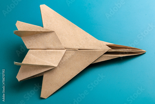 A paper airplane is sitting on a blue surface