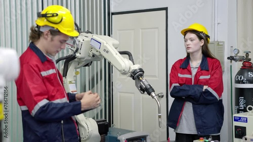 Group of multiethnic engineer researching and developing a robotics arm in scientific technology laboratory. Technician examining Industrial robot machine. Automated and manufacturing factory concepts