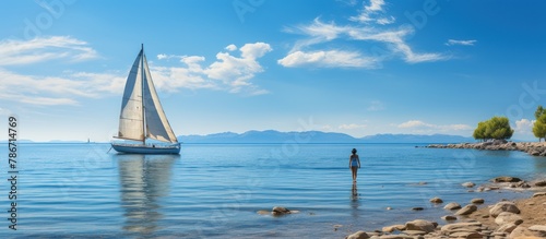 Sailboat Sailing in the middle of the sea isolated bluish clear sky photo