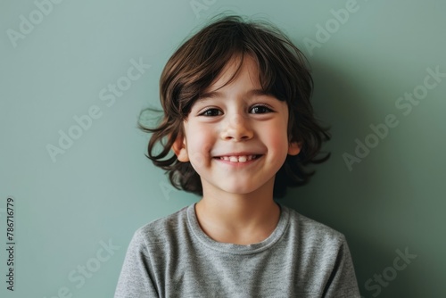 Portrait of a cute little boy with curly hair smiling at camera