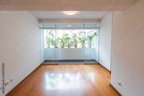 sala de departamento con balcon y plantas ornamentales