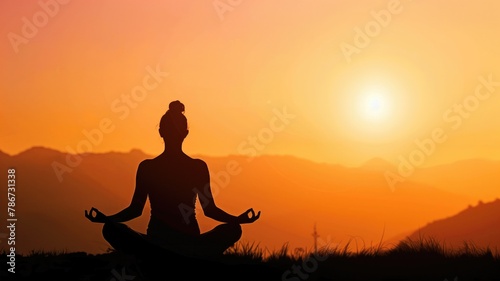 Silhouette of person meditating at sunrise in mountains