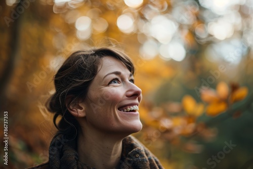 Portrait of happy young woman in autumn forest. Smiling girl. © Iigo