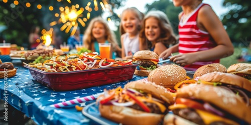 Joyful outdoor Fourth of July picnic with four children laughing, vibrant table spread featuring burgers and hot dogs, festive fireworks in background. photo
