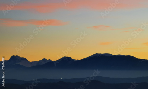 Le montagne in controluce in un luminoso tramonto arancione