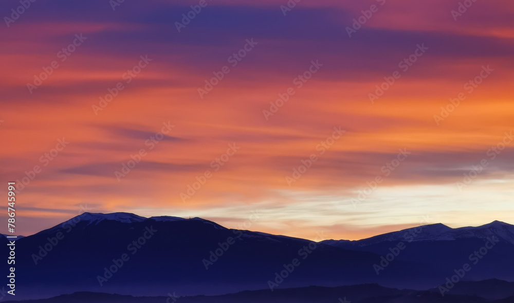Nuvole rosse al tramonto sulla cime delle montagne