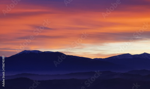 Nuvole rosse al tramonto sulla cime delle montagne