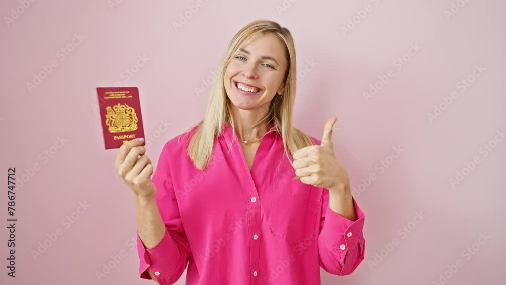 Exuberant young blonde woman gives thumbs up with north ireland passport over isolated pink background Exuberant young blonde woman gives thumbs up with north ireland passport over isolated pink background